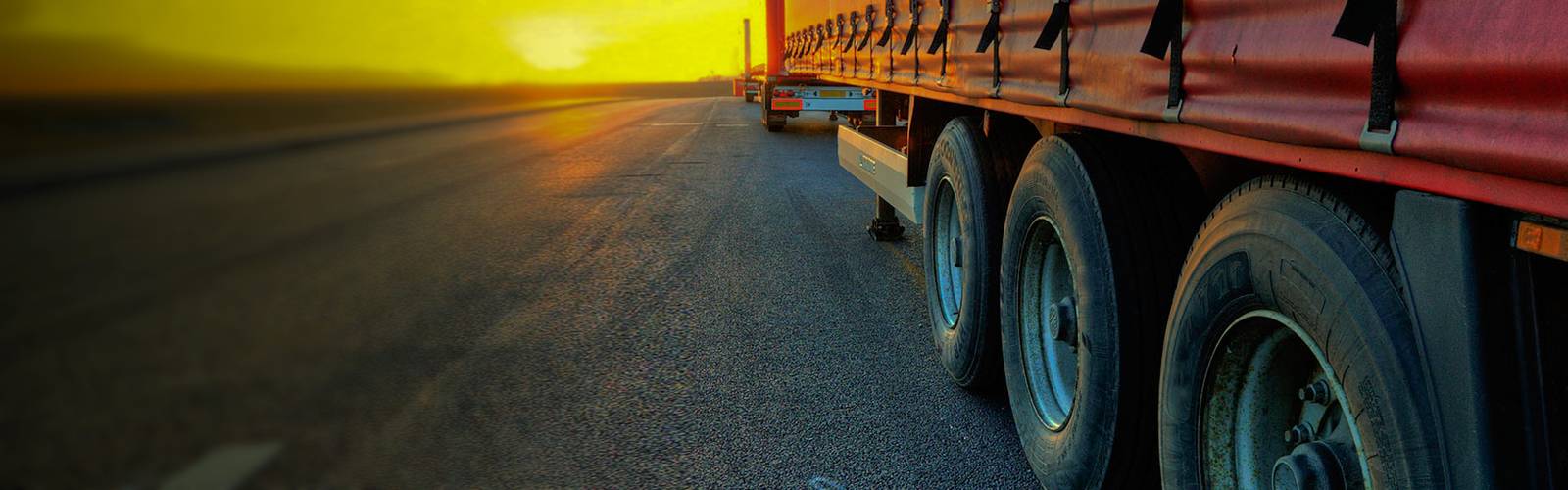 Camión de carga con lona en carretera al atardecer